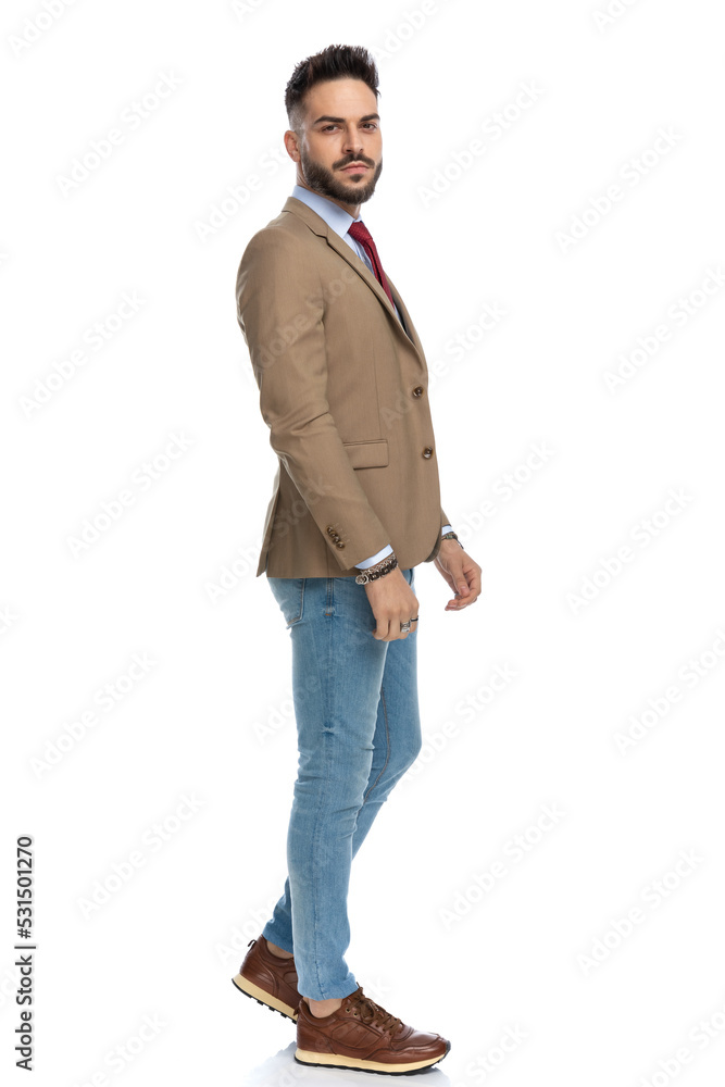 side view of handsome brunette man in smart casual outfit walking side view of handsome brunette man in smart casual outfit walking