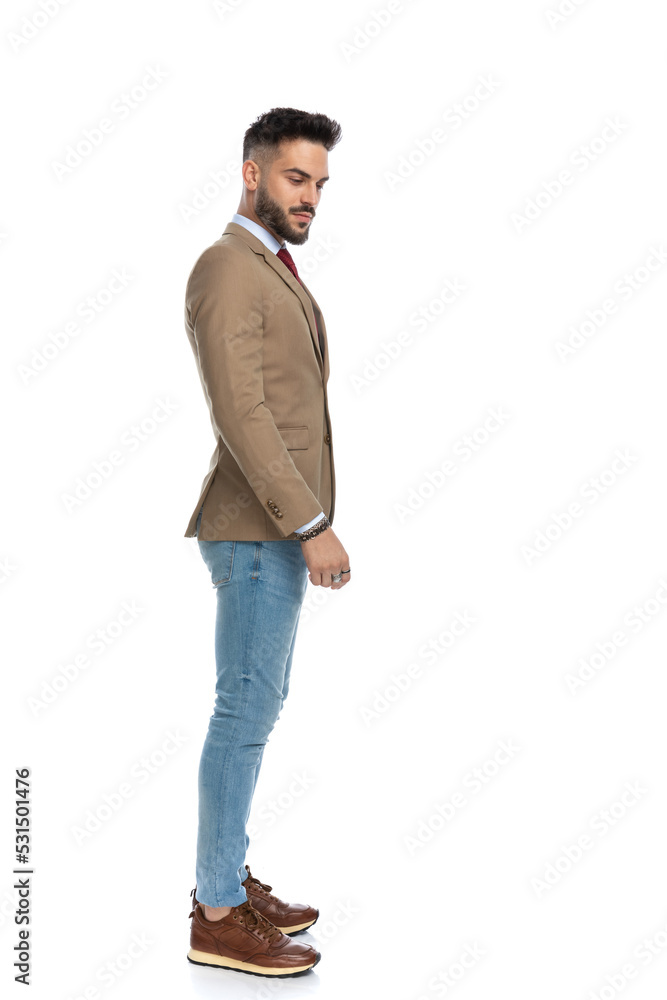 side view of bearded man in jacket looking to side and down