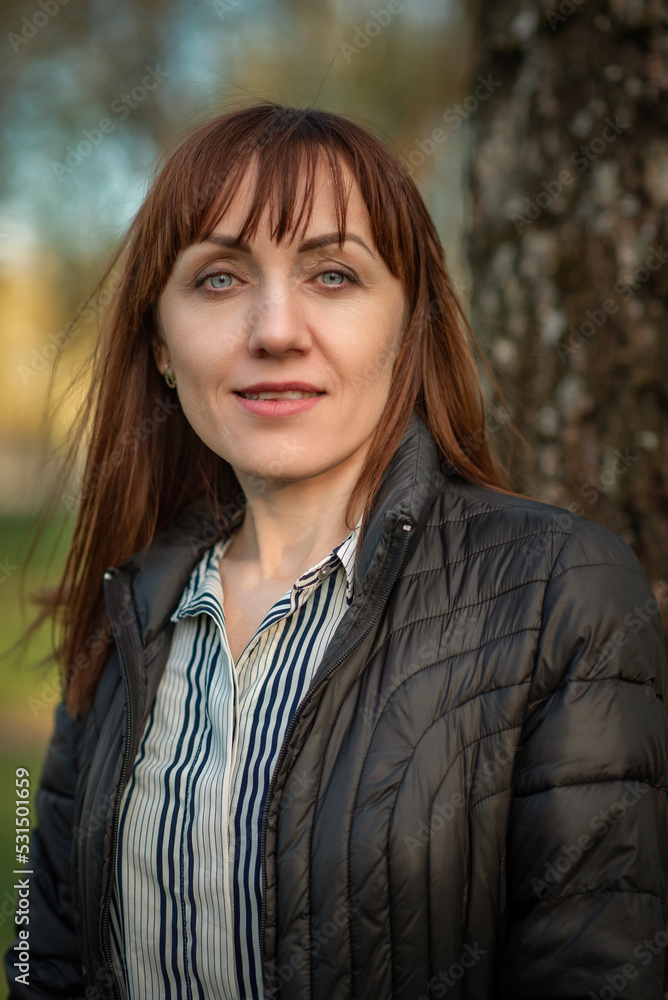 Portrait of a young beautiful red-haired girl in a spring park. There is artistic noise. Portrait of a young beautiful red-haired girl in a spring park. There is artistic noise.