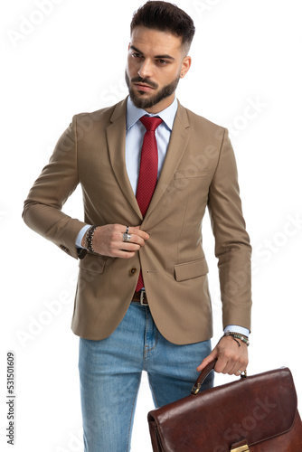 bearded businessman with suitcase unbuttoning jacket photo