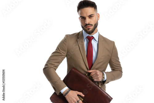 handsome elegant man with red tie opening leather suitcase photo