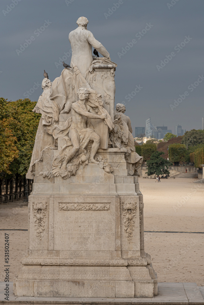 Obraz premium Paris, France - 09 16 2021: Tuileries garden. View of sculpture of Jules ferry in the park and La Defense buildings behind