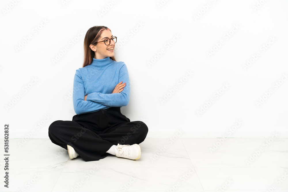 Young Caucasian woman sitting on the floor happy and smiling Young Caucasian woman sitting on the floor happy and smiling