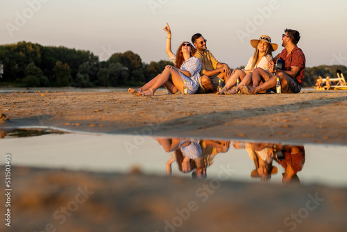 Group of friends on river beach making party and playing guitar © Nemanja