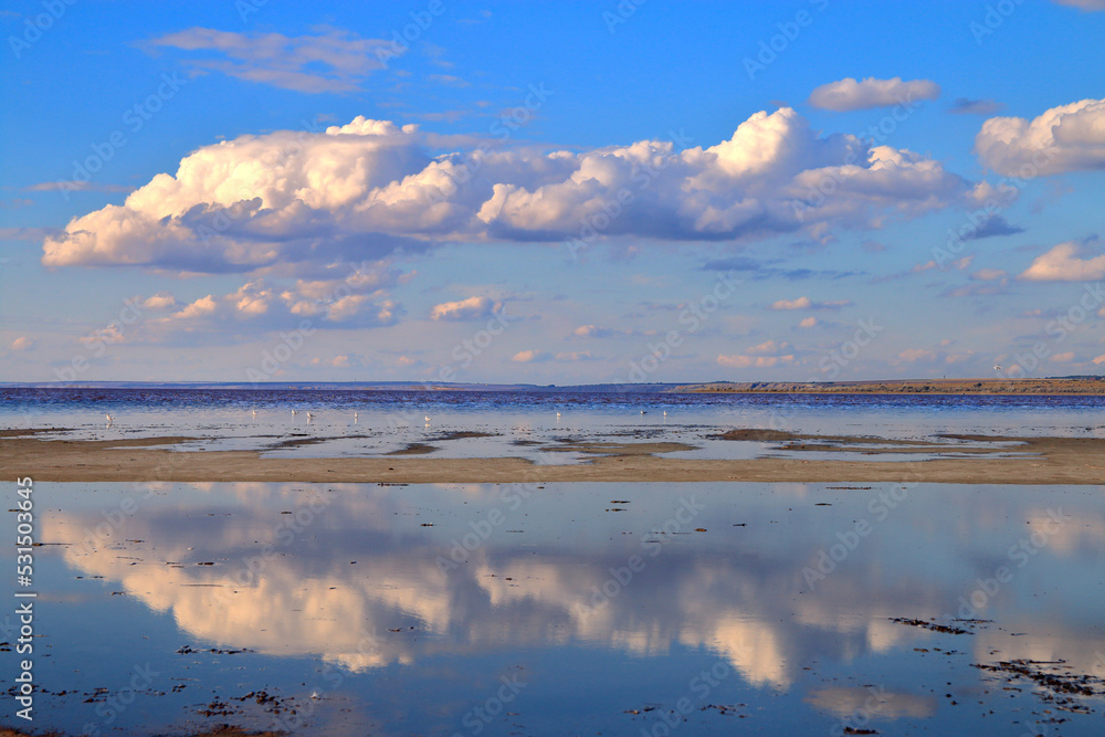 Reflecting clouds over the mirror surface of a salty shallow estuary.