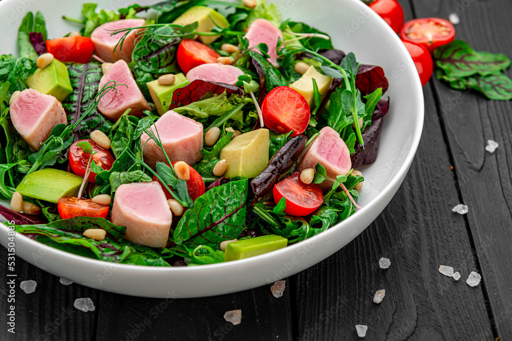 Japanese traditional salad with pieces of medium-rare grilled Ahi tuna and sesame with fresh vegetable on a bowl. Japanese traditional salad with pieces of medium-rare grilled Ahi tuna and sesame with fresh vegetable on a bowl.