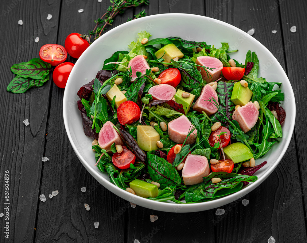 Japanese traditional salad with pieces of medium-rare grilled Ahi tuna and sesame with fresh vegetable on a bowl. Japanese traditional salad with pieces of medium-rare grilled Ahi tuna and sesame with fresh vegetable on a bowl.