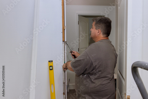 During the installation of interior doors in a new house, a trim worker uses the hammer