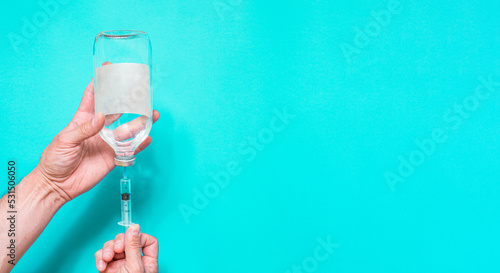 Syringe with vaccine on blue background from above