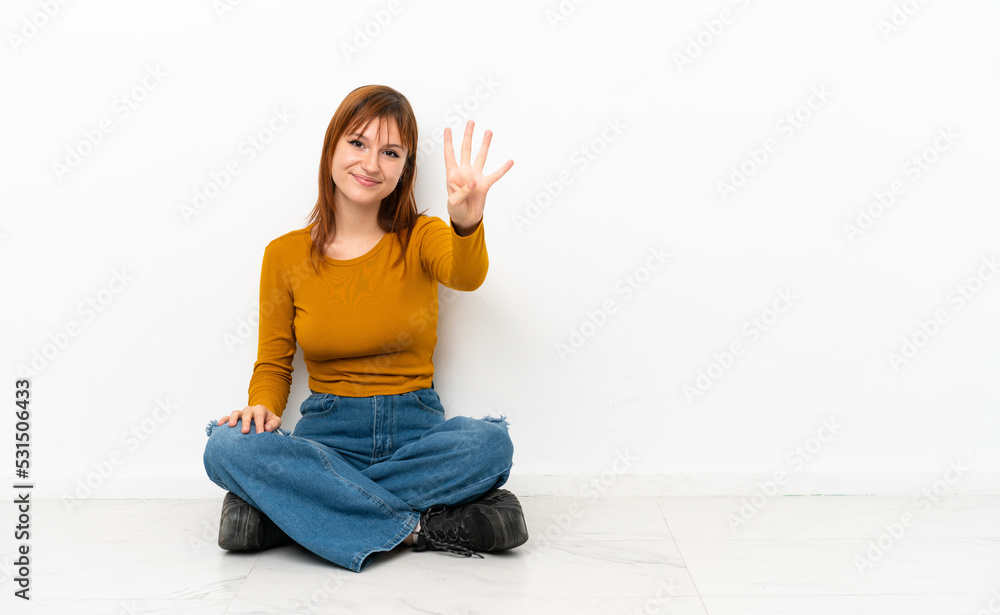 Redhead girl sitting on the floor isolated on white background happy and counting four with fingers Redhead girl sitting on the floor isolated on white background happy and counting four with fingers