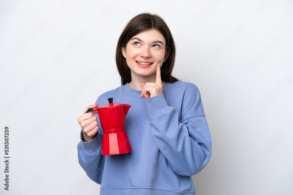 Young Russian woman holding coffee pot isolated on white background thinking an idea while looking up Young Russian woman holding coffee pot isolated on white background thinking an idea while looking up