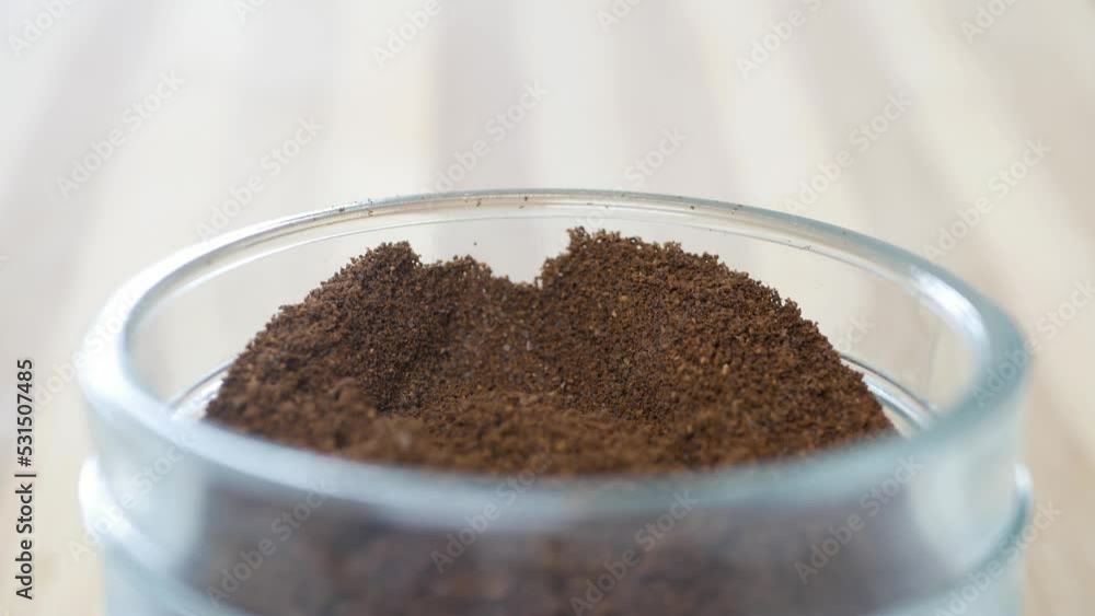 Shooting with a Person Putting a Teaspoon of Freshly Ground Coffee in a Coffee Jar. Preparing a Fresh Coffee in the Morning. Shooting with a Person Putting a Teaspoon of Freshly Ground Coffee in a Coffee Jar. Preparing a Fresh Coffee in the Morning.