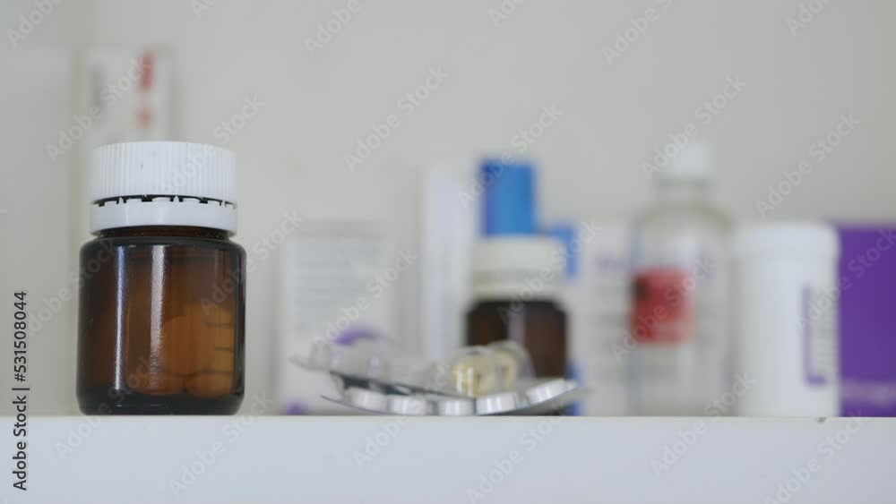 Older Man Opening a Medicine Cabinet, Puts Some Medical Pills Inside. Older Man Opening a Medicine Cabinet, Puts Some Medical Pills Inside.