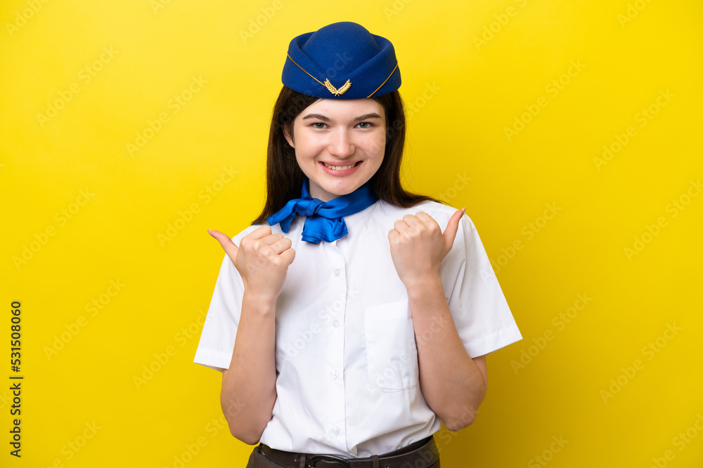 Airplane stewardess Russian woman isolated on yellow background with thumbs up gesture and smiling Airplane stewardess Russian woman isolated on yellow background with thumbs up gesture and smiling