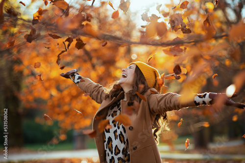 smiling 40 years old woman in brown coat and hat rejoicing photo