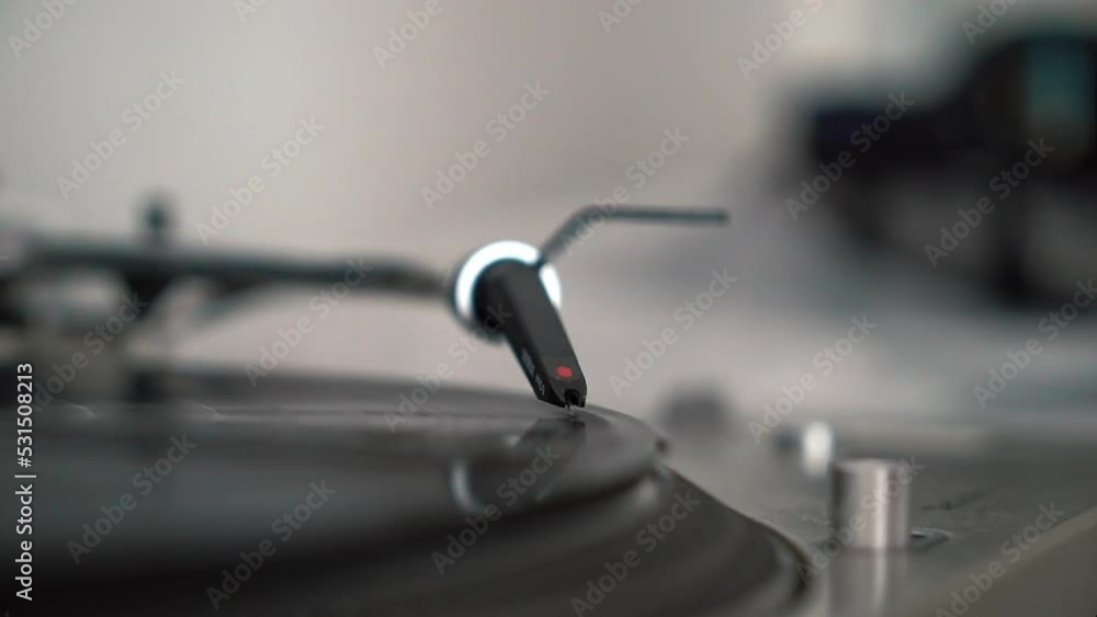 Man hand adjusts the head old record player and vinyl discs at home. Using vinyl audio player. Music lover listens to classical music. Close up. High quality FullHD footage Man hand adjusts the head old record player and vinyl discs at home. Using vinyl audio player. Music lover listens to classical music. Close up. High quality FullHD footage