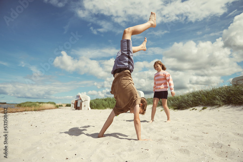 Happy teen children joyful playing on white beach at summer holidays