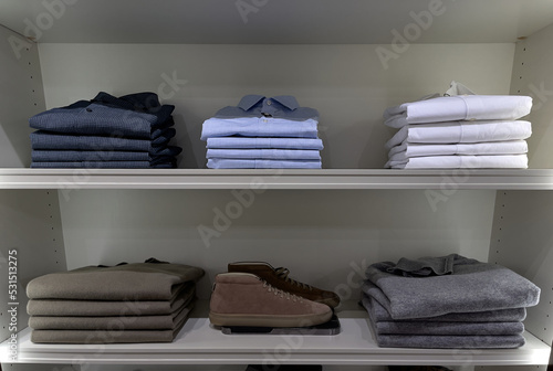 Clothes neatly folded on a shelf in a store © pridannikov