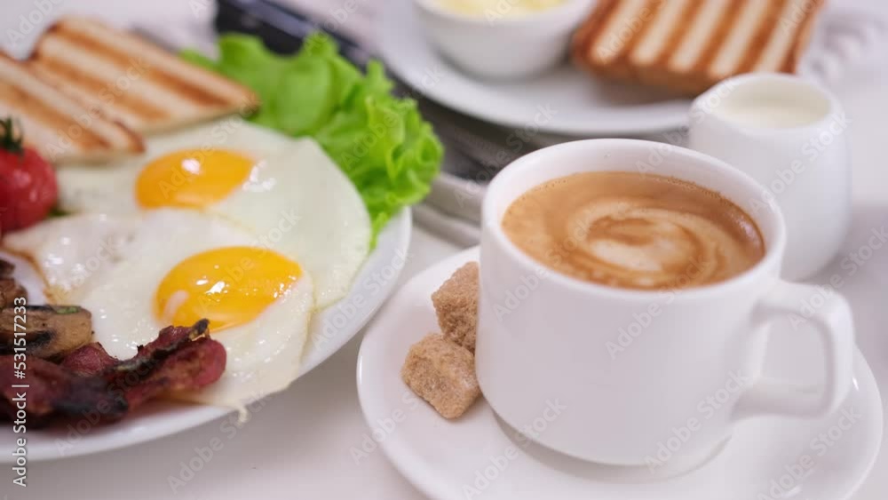 tasty breakfast - cherry tomatoes, fried mushrooms, bacon and eggs on white ceramic plate and cup of espresso tasty breakfast - cherry tomatoes, fried mushrooms, bacon and eggs on white ceramic plate and cup of espresso