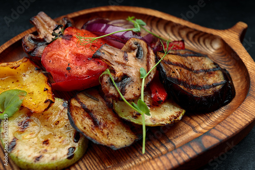 Grilled vegetables with mushrooms on a wooden board photo