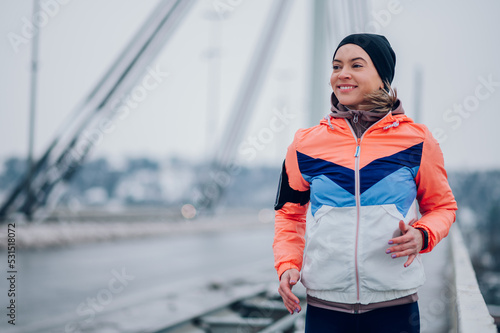 Woman running on the bridge at winter and snow.