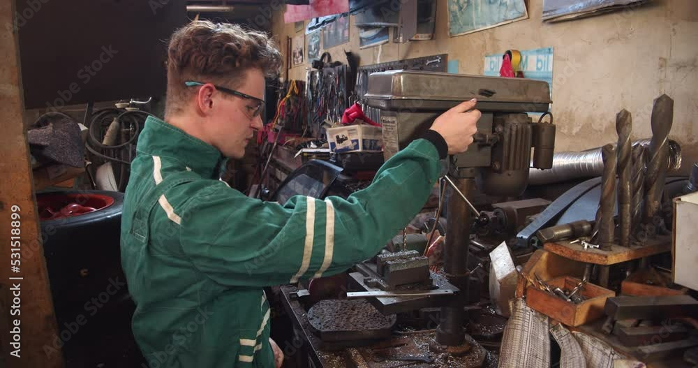 Experienced mechanic working with a drill in an auto workshop Experienced mechanic working with a drill in an auto workshop