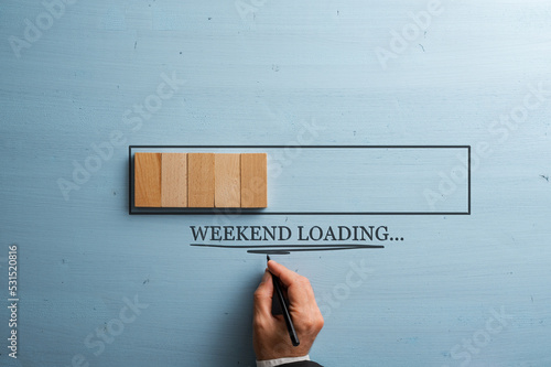 Male hand writing a Weekend loading sign under a loading bar