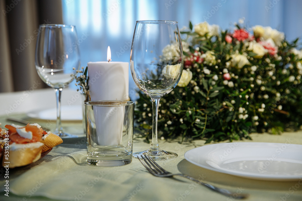The table is decorated with plates and glasses with flowers on the table