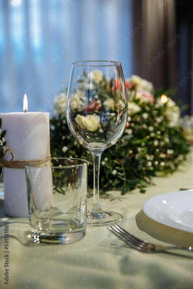 The table is decorated with plates and glasses with flowers on the table The table is decorated with plates and glasses with flowers on the table