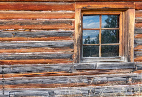 Old Cabin window with reflection of the mountains
