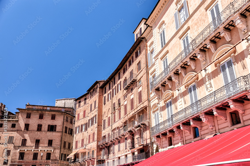 Sienna, Italy - July 14, 2022: Building facades and architectural features surrounding the Piazza del Campo in Siena Italy
