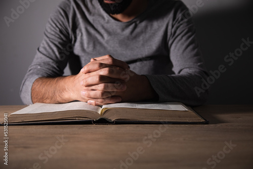 Valokuvatapetti Man praying on a book