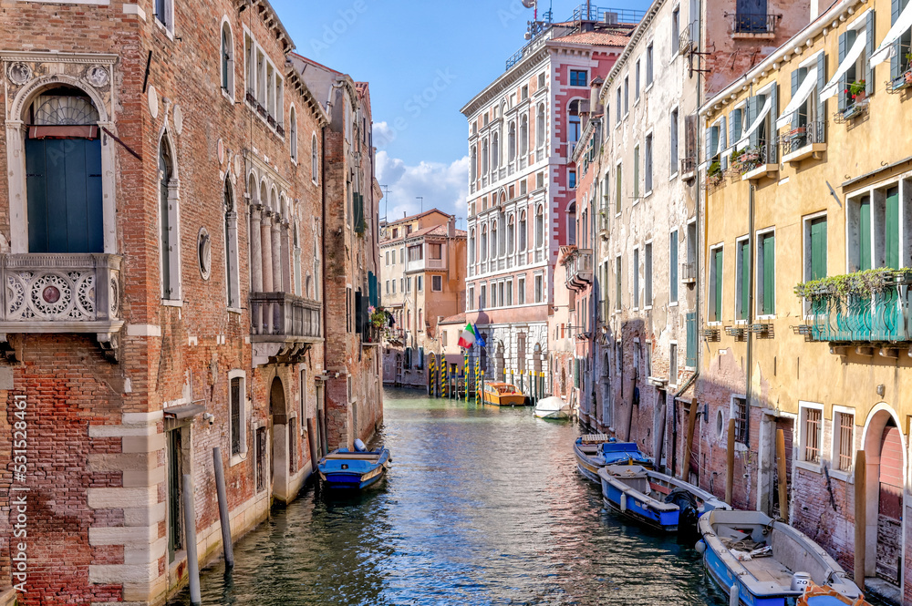 Venice, Italy - July 5, 2022: Building exteriors, boats and gondolas along the canals in Venice Italy
