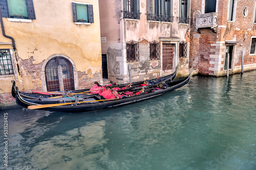 Venice, Italy - July 5, 2022: Building exteriors, boats and gondolas along the canals in Venice Italy  © Torval Mork