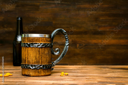 Big brown mug of beer,ale bottle and crispy snacks, pretzels, corn, nuts in bowl on wooden table, background close up. Alcohol cocktail, bar drink, booze party concept.mockup, template, copy space