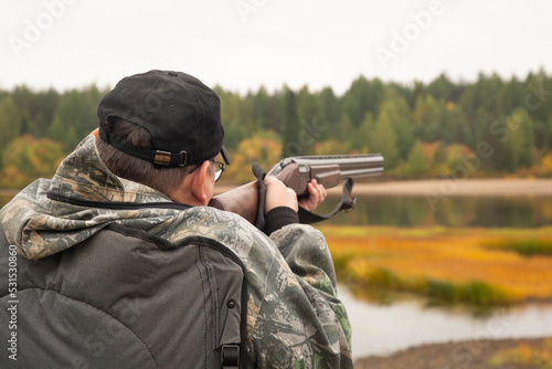 Duck hunting in autumn. A man with a gun is hunting ducks.