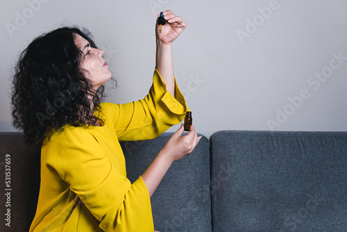 Adult woman using and holding medical cannabis oil. CBD. Concept of herbal and alternative medicine