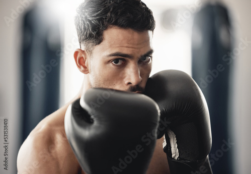 Fitness portrait of man boxer ready to punch during mma, boxing or fighting workout. Athlete boxing in the gym during training, exercise or practice for a fight, match or competition at a sport club © Beaunitta V W/peopleimages.com