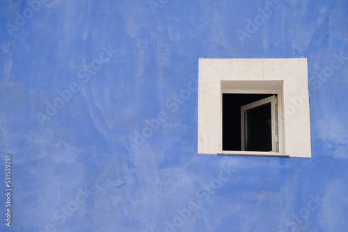 Colorful blue colored facade with window details on a Latin Colonial building. © ruthlaguna