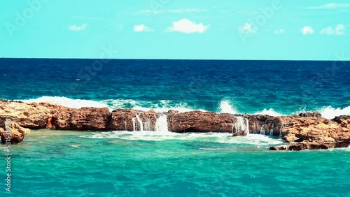 Video of lazur sea waves hitting the big stones photo