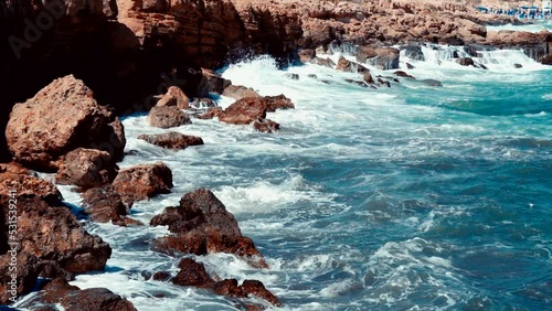 Video of lazur sea waves hitting the big stones photo