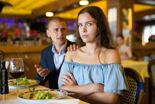 Depressed family couple man and woman sitting at restaurant unhappy after quarrel