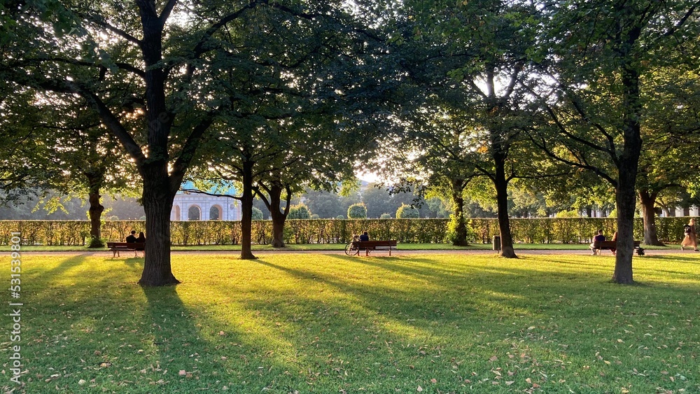Obraz premium Park visitors on benches in the sunny Hofgarten Munich