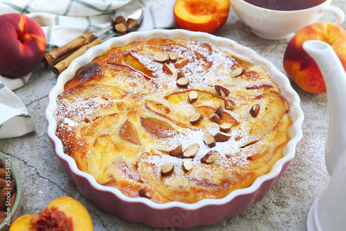 Nectarine clafoutis (flan) with almonds, icing sugar dressing and cup of tea