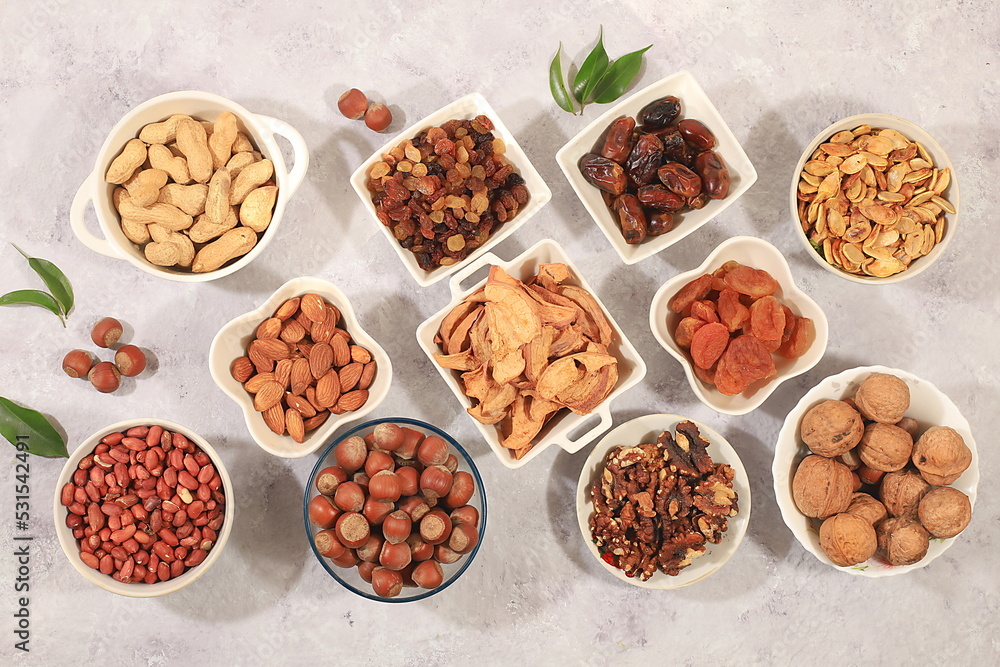 Assortment of various nuts and dried fruits, healthy natural food concept, almonds, nuts, pecans, pistachios, cashews, walnuts and pine nuts, apples, raisins, dried apricots, f Assortment of various nuts and dried fruits, healthy natural food concept, almonds, nuts, pecans, pistachios, cashews, walnuts and pine nuts, apples, raisins, dried apricots, f