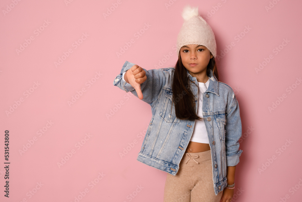Portrait of cool girl showing thumbs down gesture isolated on pink studio wall, banner, free space Portrait of cool girl showing thumbs down gesture isolated on pink studio wall, banner, free space