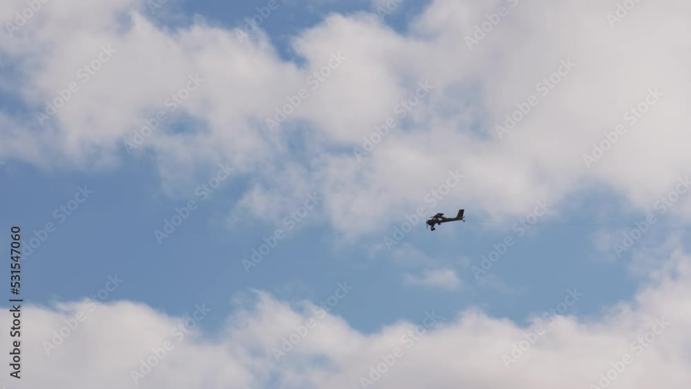 Flying silhouette small civil aircraft in sky. Double seat plane flies forward in cloudy sky. agricultural air vehicle carrying employee or business owner flies to work. Flying silhouette small civil aircraft in sky. Double seat plane flies forward in cloudy sky. agricultural air vehicle carrying employee or business owner flies to work.