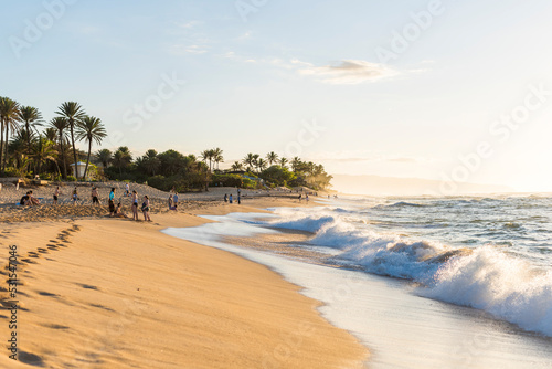 Sunset Beach, Oahu Hawaii, USA – circa February 2018: People at Sunset beach at sunset. Sunset Beach is located on the north shore of Oahu and is the best place to watch the sunset in the island