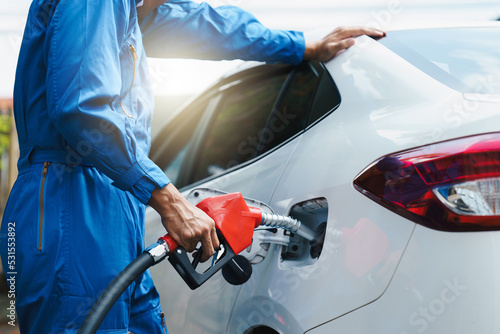 Male hand close up refueling a white car, Fuel gasoline car in gas station, to fill the machine with fuel. © PaeGAG