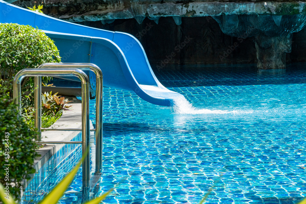 Blue water slide with flowing water. Blue water swimming pool at the